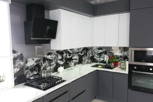 Кухня со стеклянным фартуком, с фасадами серого цвета и белой мраморной столешницей с еврозапилом.