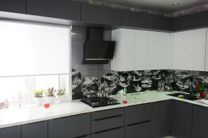 Кухня со стеклянным фартуком, с фасадами серого цвета и белой мраморной столешницей.