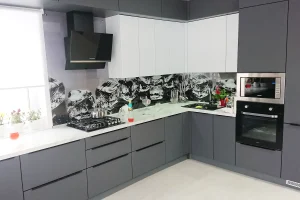 Кухня со стеклянным фартуком, с фасадами серого цвета и белой мраморной столешницей.